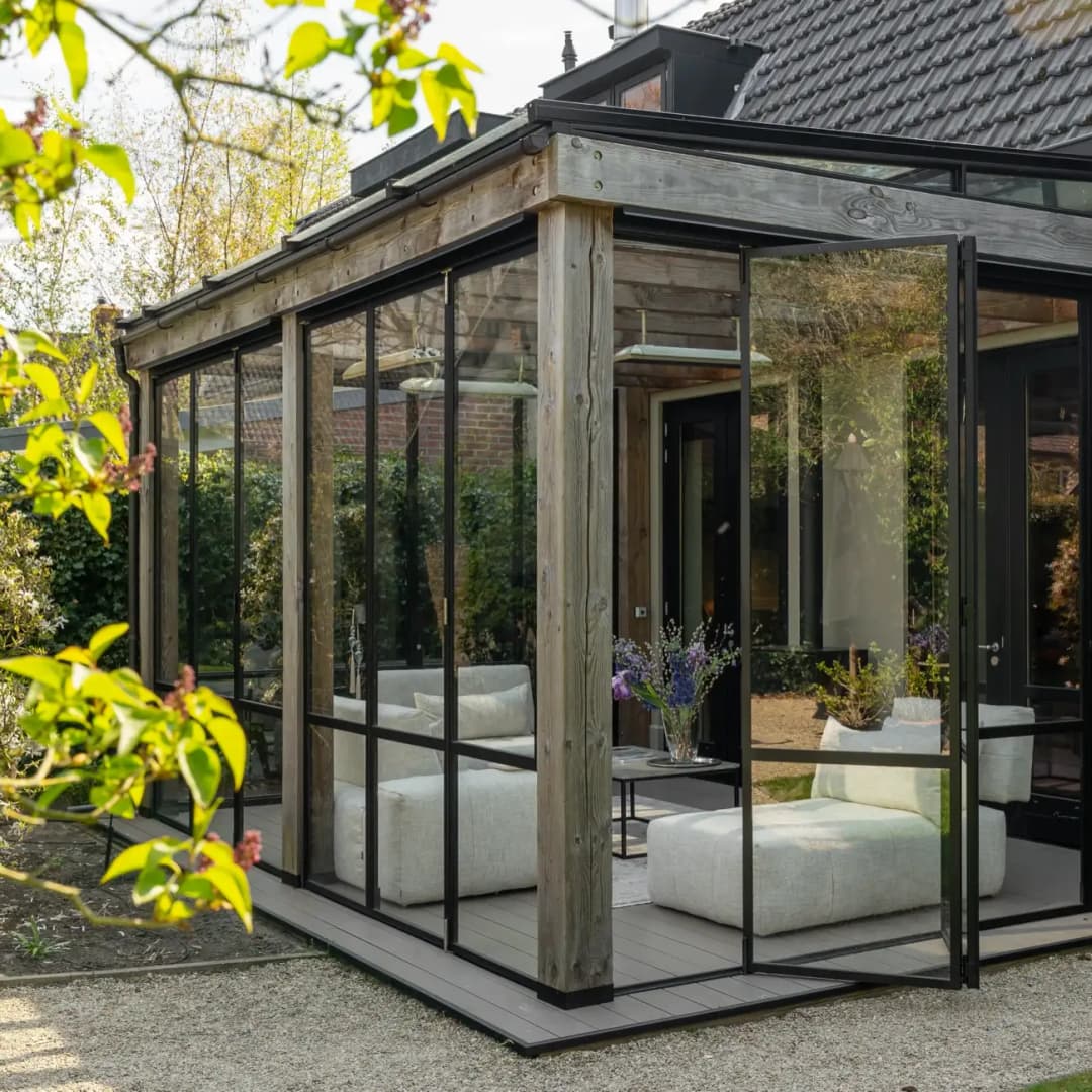 Een tuinkamer met stalen vouwdeuren