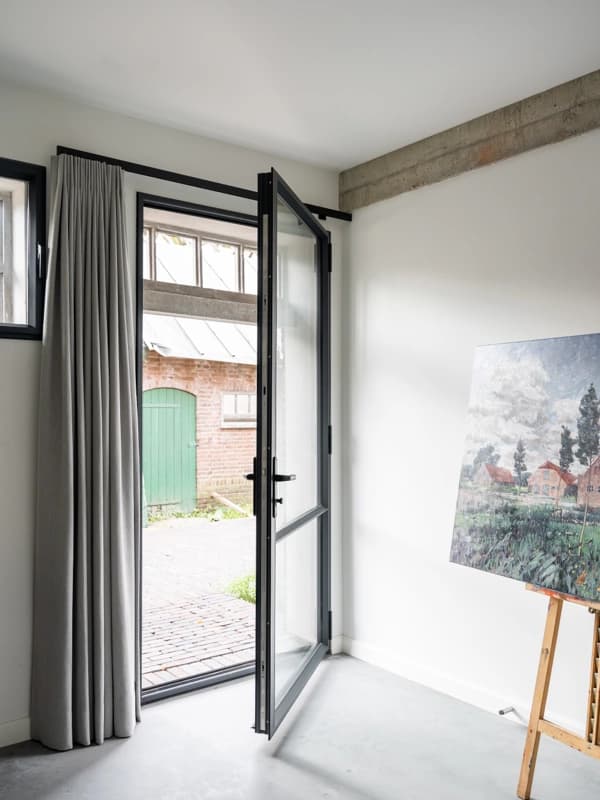 Openstaande stalen buitendeur op een boerenerf